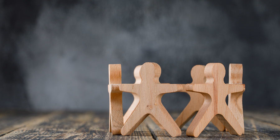 Business success and teamwork concept with wooden figures of peo